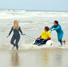 In de zee op het starnd in Katwijk aan Zee met een via ons te huren Hypocampe lichtgewicht strandrolstoel